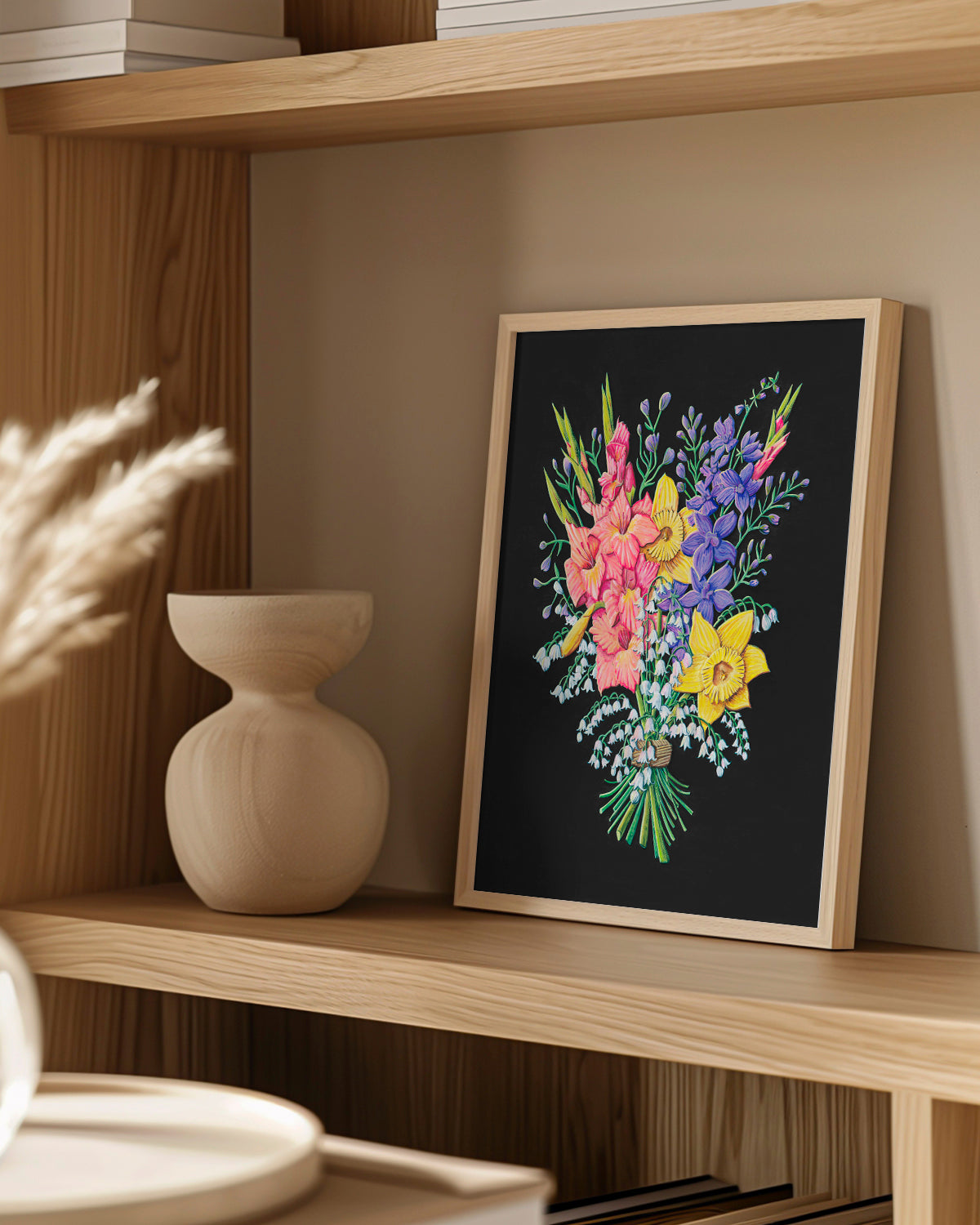 Framed floral artwork by Jen Montgomery on a wooden shelf with a vase and decorative items.