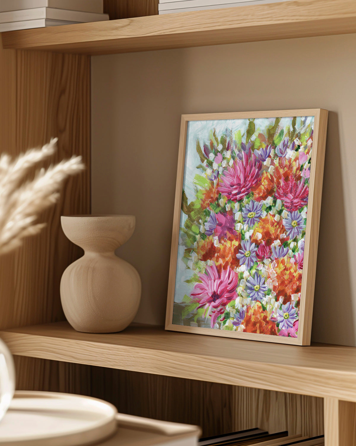 Bouquet No. 005 framed canvas art print featuring vibrant pink, orange, and purple flowers. Mocked up on a wooden shelf with a vase and decorative items.