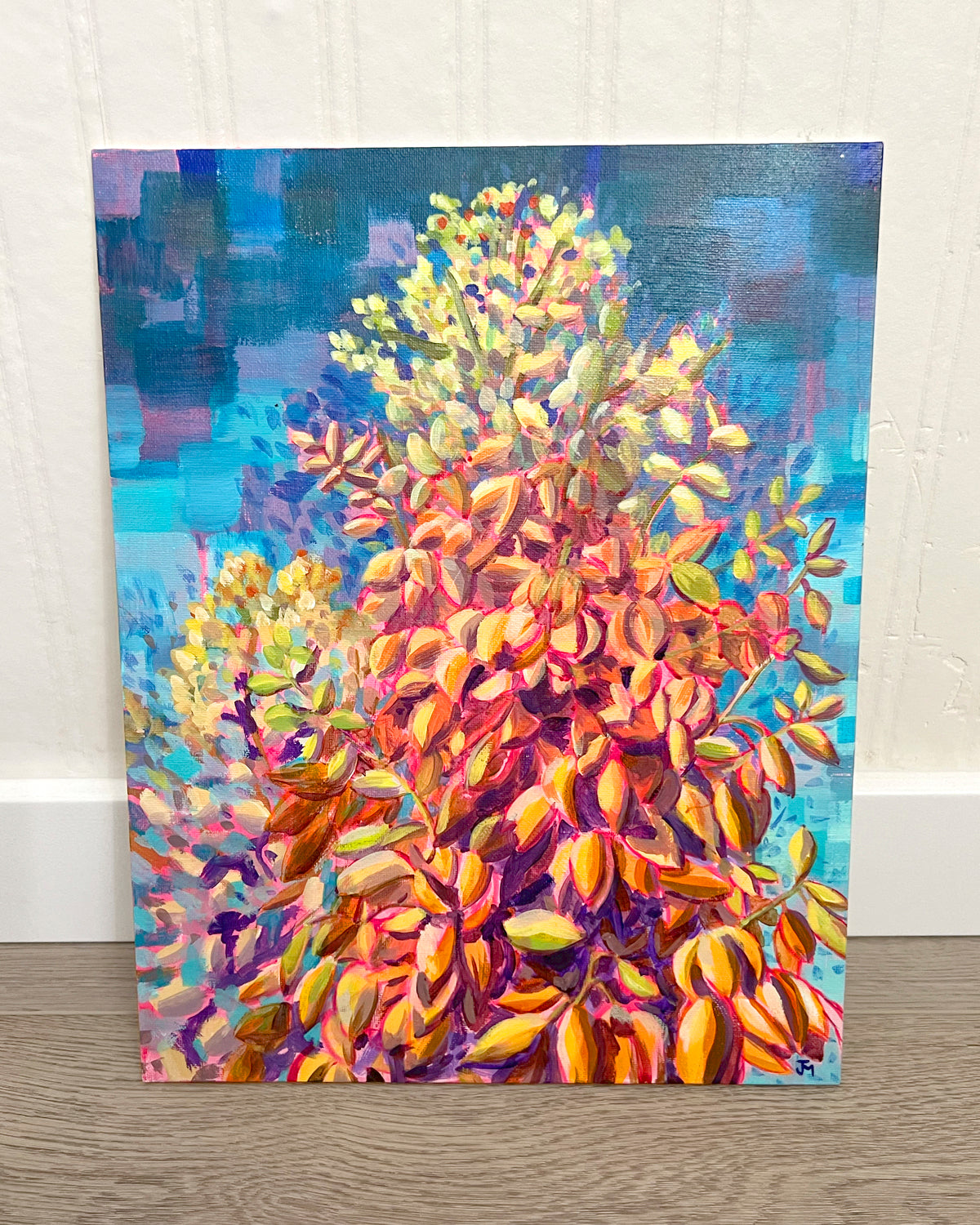 Close-up of an acrylic painting by Jen Montgomery showing a yucca plant with yellow, green, and orange brushstrokes against a textured blue and purple background, mounted on a white wall.